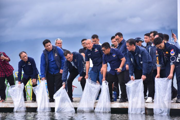 Wakil Ketua DPR RI, Saan Mustopa, saat menebar ribuan benih ikan ke Danau Toba dalam kunjungannya ke Sumatera Utara. Foto: Dokumen Parlementaria (Eno/vel)