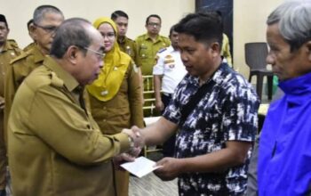 Wali kota Gorontalo, Adham Dambea saat menyerahkan bantuan BBM kepada pengemudi bentor. Foto: Humas Pemkot