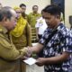 Wali kota Gorontalo, Adham Dambea saat menyerahkan bantuan BBM kepada pengemudi bentor. Foto: Humas Pemkot