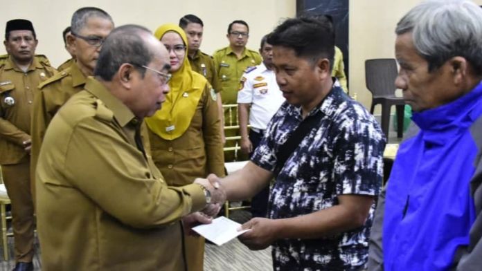 Wali kota Gorontalo, Adham Dambea saat menyerahkan bantuan BBM kepada pengemudi bentor. Foto: Humas Pemkot