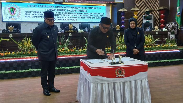 Ketua DPRD Kota Gorontalo, Irwan Hunawa saat menandatangani persetujuan Ranperda pembentukan Badan Pendapatan Daerah (Bapenda). Foto: Arlan